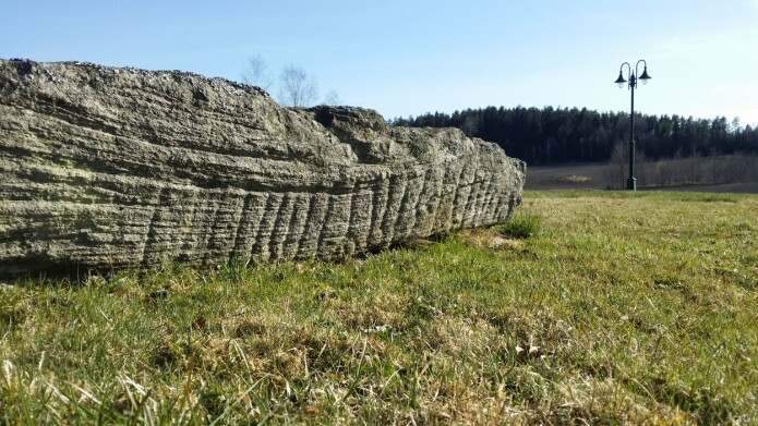 Dette er det første bildet av runesteinen, som ble tatt av nabo Emil Omenås før forskerne fikk fingrene i den. I bakgrunnen ser du «Sparreåsen», der steinen opprinnelig har stått. (Foto: Emil Omenås) Dette er det første bildet av runesteinen, som ble tatt av nabo Emil Omenås før forskerne fikk fingrene i den. I bakgrunnen ser du «Sparreåsen», der steinen opprinnelig har stått. (Foto: Emil Omenås)