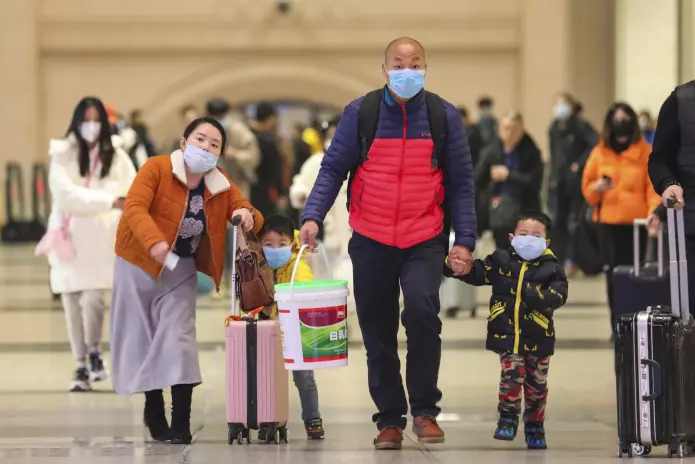 En kinesisk familie med munnbind på togstasjonen Hankou i Wuhan 21. januar i år.