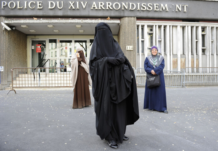 To kvinner med ansiktsdekkende plagg kommer ut av en politistasjon i Paris etter å ha blitt bøtelagt for klærne sine i april 2011. To kvinner med ansiktsdekkende plagg kommer ut av en politistasjon i Paris etter å ha blitt bøtelagt for klærne sine i april 2011.