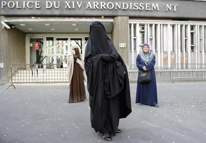 To kvinner med ansiktsdekkende plagg kommer ut av en politistasjon i Paris etter å ha blitt bøtelagt for klærne sine i april 2011.