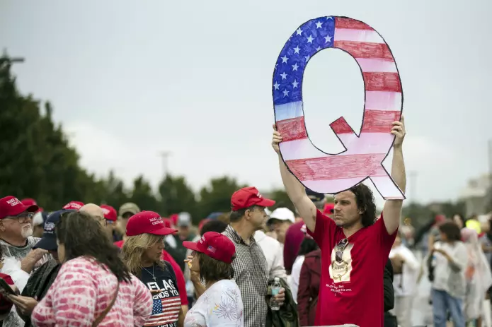 En Trump-tilhenger med et hjemmelaget QAnon-skilt utenfor et Trump-rally i 2018.