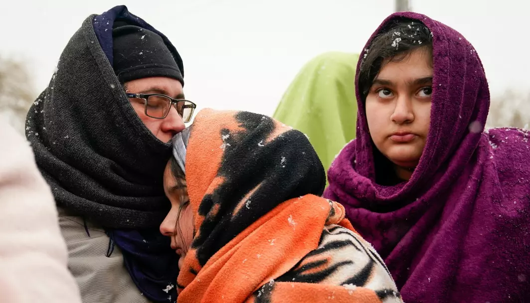 En afghansk familie, som tidligere har flyktet fra krigen i Afghanistan, venter på frakt til et flyktningmottak i Medyka, Polen, etter å ha flyktet fra krigen i Ukraina.