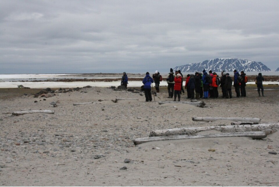 Turister i Smeerenburg. Det er ikke alltid lett å forstå at de lave sandhaugene på stranden er fredete kulturminner.