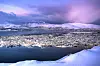 Panoramautsikt over Tromsø om vinteren med snø, fjord og blåtimehimmel.