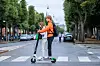 To unge på en Lime-el-sparkesykkel krysser et fotgjengerfelt.