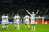 Erling Braut Haaland slår armene ut på fotballbanen, fem andre lagkamerater sees med ryggen til. I bakgrunnen skimtes stadion full av publikum.
