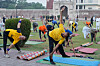 Deltakere gjør yogaøvelser på matter i en park i Lahore under International Yoga Day.