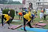 Deltakere gjør yogaøvelser på matter i en park i Lahore under International Yoga Day.