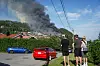 Stor røyksøyle over boligområde ved Krokstadelva i Drammen, sett fra en vei med personer i forgrunnen.