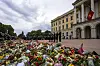 Et stort blomsterhav foran Slottet i Oslo, med norske flagg og sørgende besøkende.