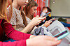 Gruppe barn sitter sammen og bruker smarttelefoner.
