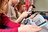 Gruppe barn sitter sammen og bruker smarttelefoner.