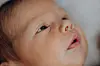 Nærbilde av en babys ansikt. Øynene er åpne.